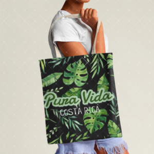 Bolso negro con hojas verdes tropicales y frase Pura Vida Costa Rica, sostenido por asas claras.